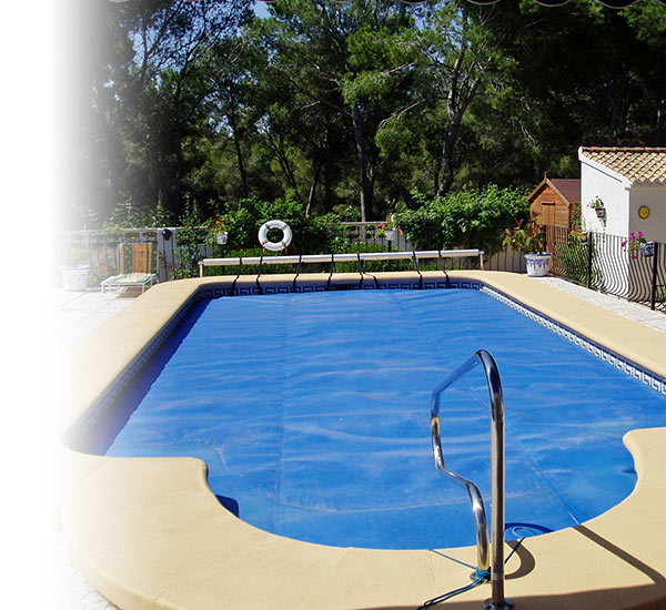 Piscine creusée recouverte d'une bâche bleue